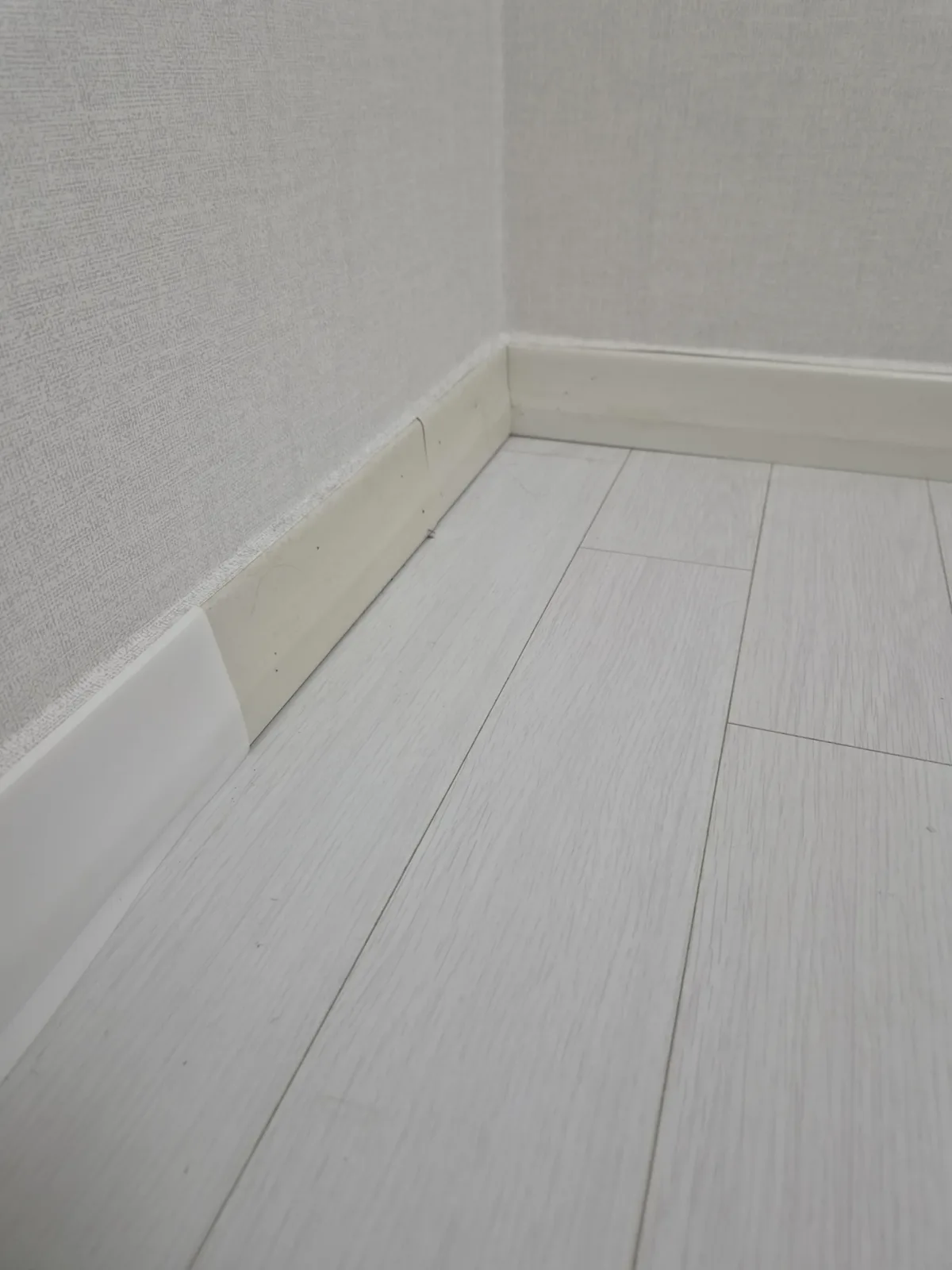 걸레받이 전체교체 전 모서리에서 서로 색이 다른 조각을 이어 붙여 얼룩덜룩해진 걸레받이